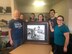 The Elliott family poses with their 1985 family portrait that shows retired Lt. Col. Gary, far left, being welcomed back to Moody Air Force Base, Ga., after a deployment, by his wife and kids, June 18, 2017. After being notified of this portrait, the Elliot family searched for the photo for approximately 20 years. Upon receiving orders to Moody in 2015, Maj. Jonathan Elliott, 23d Logistics Readiness Squadron director of operations, continued to search for the snapshot, obtaining it in 2016. (Courtesy photo)