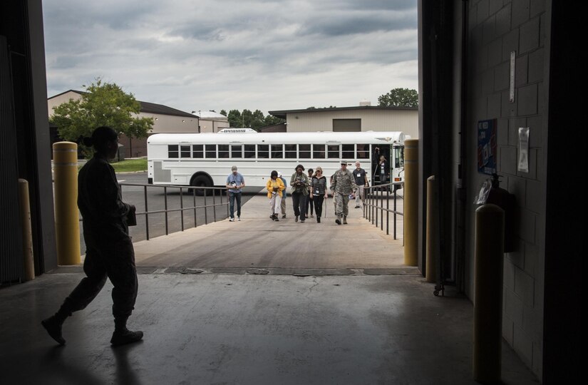 Members of the Joint Civilian Orientation Conference step off the bus at the 305th Aerial Port Squadron warehouse as part of the "Air Force" day tour on Joint Base McGuire-Dix-Lakehurst, N.J., Aug. 11, 2017. The conference is geared toward increasing public understanding of national defense by enabling community and business leaders an opportunity to see first-hand the missions of the U.S. military during a week-long tour of installations from across the DOD. (U.S. Air Force photo by Senior Airman Lauren Russell)
