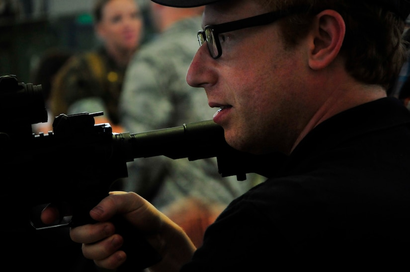 A member of the Joint Civilian Orientation Conference looks through the site of a firearm during a Security Forces exhibit at the 621st Contingency Response Wing Global Readiness Deployment Center on Joint Base McGuire-Dix-Lakehurst, N.J., Aug. 11, 2017. The only outreach program sponsored by the Secretary of Defense, the JCOC is the most prestigious public liaison program in the Department of Defense. (U.S. Air Force photo by Senior Airman Lauren Russell)