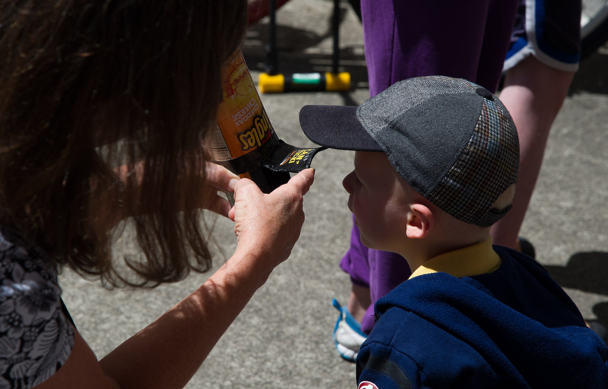 Samuel Bielefeld peers through the opening of cardboard container modified to safely view a solar eclipse outside of the McChord Library on Joint Base Lewis McChord. His family is planning on viewing the total eclipse on August 21, 2017 from Washington State as the weather permits.