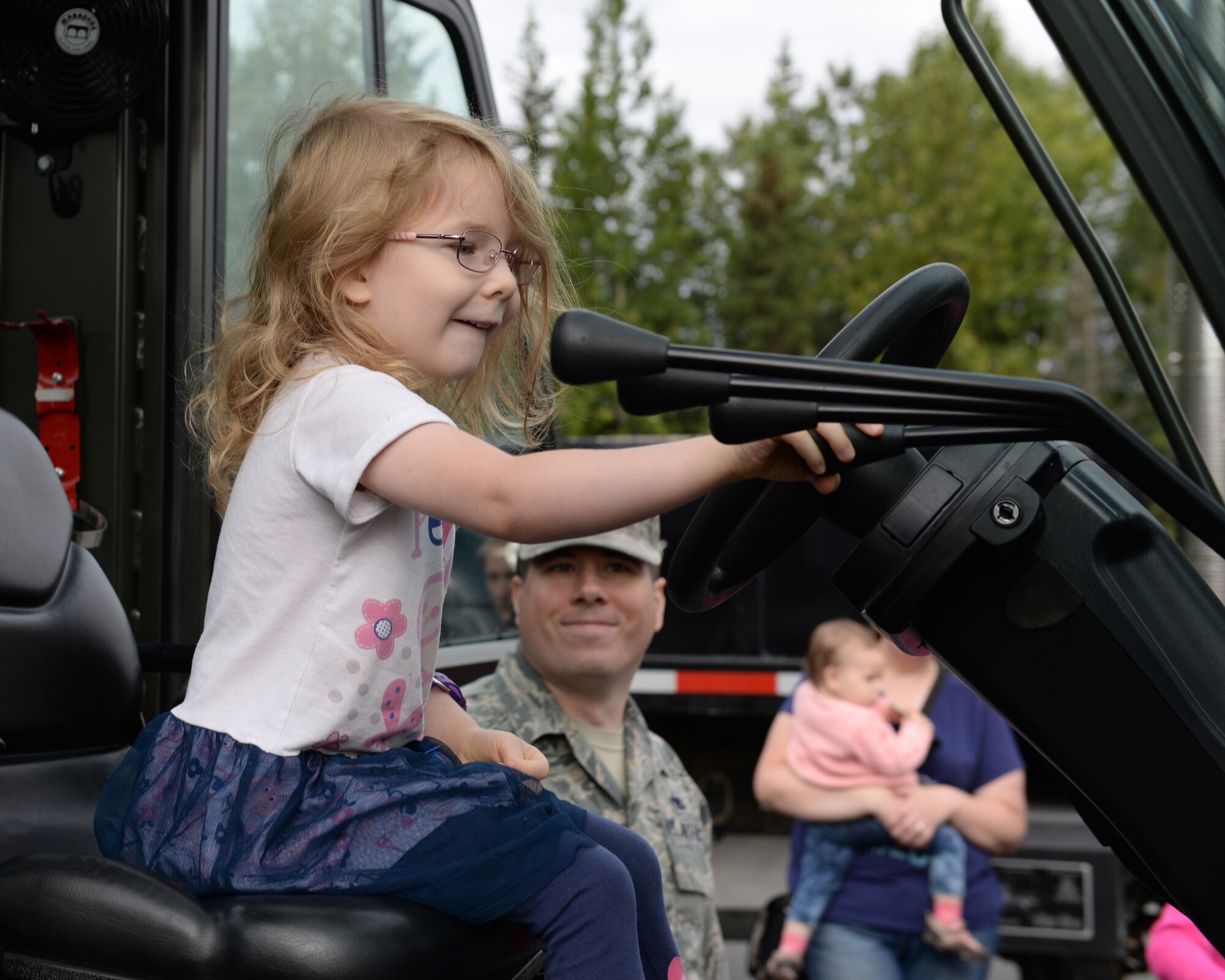 Kaylee, 4, the daughter of Staff Sgt. Jonathan Owen of the 3rd Munitions Squadron, pulls a lever on a forklift Aug. 15 at Joint Base Elmendorf-Richardson, Alaska. During the second annual Family Orientation Day hosted by the 3rd MUNS, military members’ children had the chance to experience some of the daily activities their parents’ do while at work.