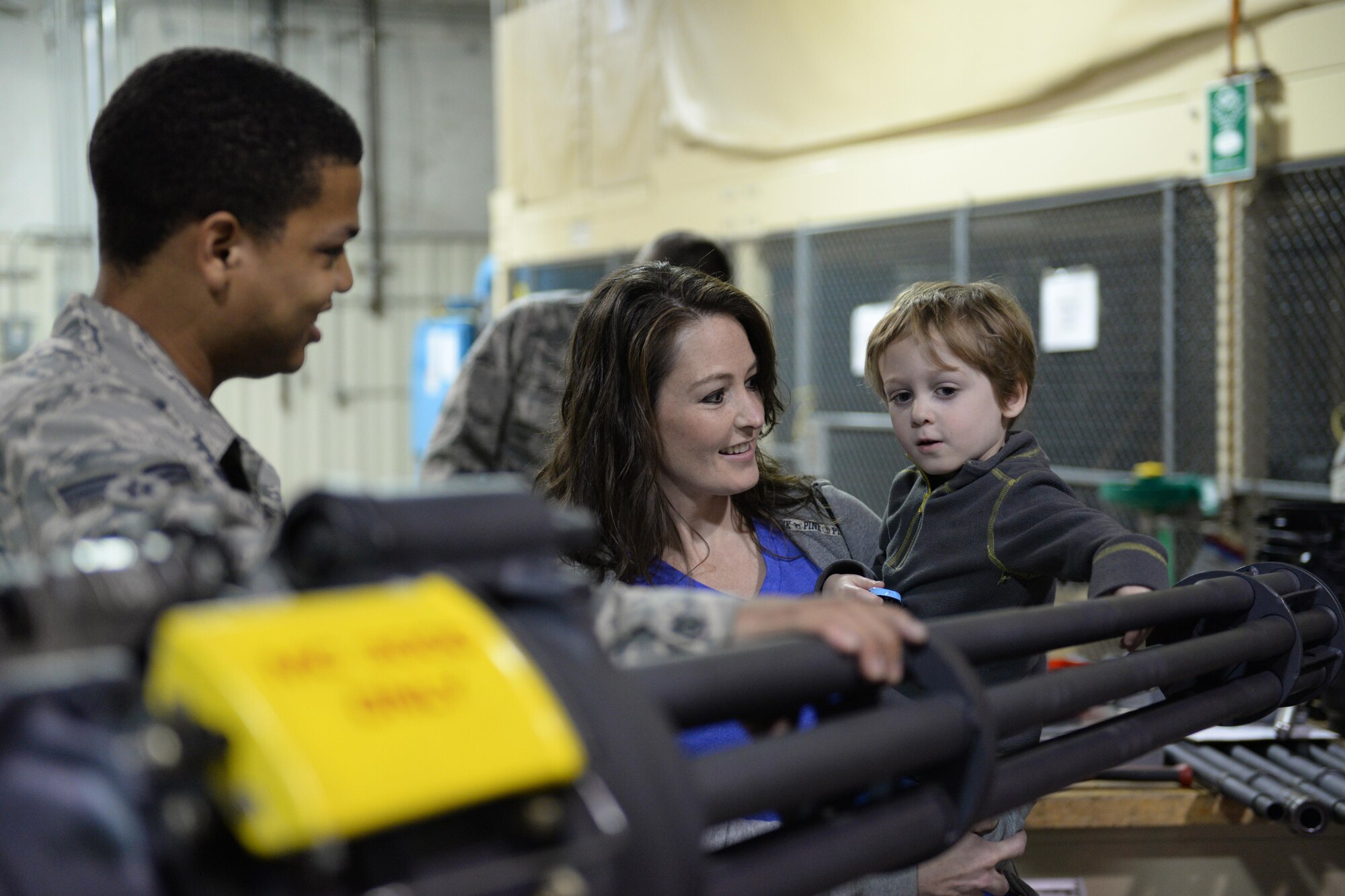 Wife Terri Anne and Kylan,4, the son of Staff Sgt. Cliffton L. Boyle, 3rd Munitions Squadron armament shop, look at a 20 mm Gatlin gun Aug. 15 at Joint Base Elmendorf-Richardson, Alaska. The 3rd MUNS is responsible for handling, storing, transporting, arming and disarming non-nuclear weapons systems, and was hosting their second annual Family Orientation Day.