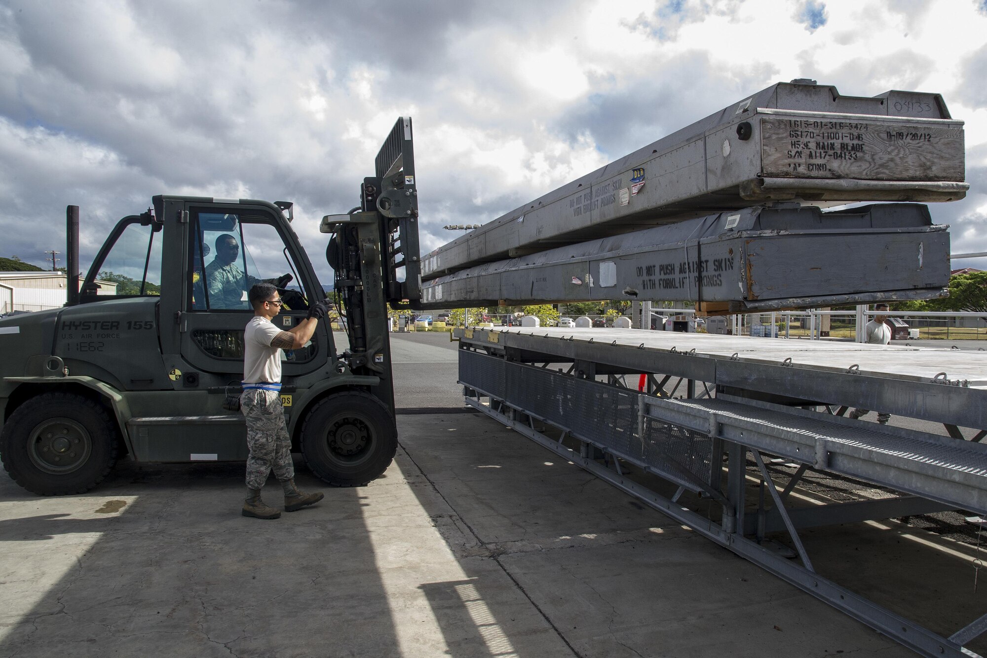 U.S. Air Force Senior Airman Keven Fuentes, of Mililani, guides Staff Sgt. Adrian Faustino, of Waipahu, while he loads equipment onto a pallet-train at Joint Base Pearl Harbor-Hickam, Hawaii, Aug. 17, 2017. Both members are air transportation specialists for the Air Force Reserve's 48th Aerial Port Squadron. The 48th APS provides expertise in all areas of air terminal operations to include aircraft loading, cargo processing and inspecting, passenger services, aircraft fleet services and aerial port command and control.