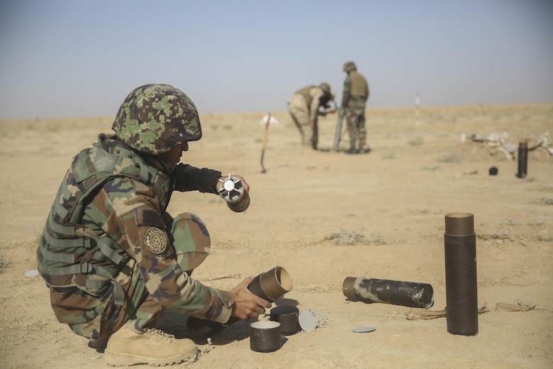 An Afghan National Army soldier with the Helmand Regional Military Training Center uncases an 82mm mortar during a live-fire range at Camp Shorabak, Afghanistan, Aug. 17, 2017. U.S. Marine advisors with Task Force Southwest are currently working with RMTC instructors to enhance their infantry knowledge and teaching skills. The RMTC is scheduled to begin an operational readiness cycle with 6th Brigade, 1st Kandak, 215th Corps in September, an eight-week course designed to increase warfighting abilities and lethality of Afghan soldiers. (U.S. Marine Corps photo by Sgt. Lucas Hopkins)