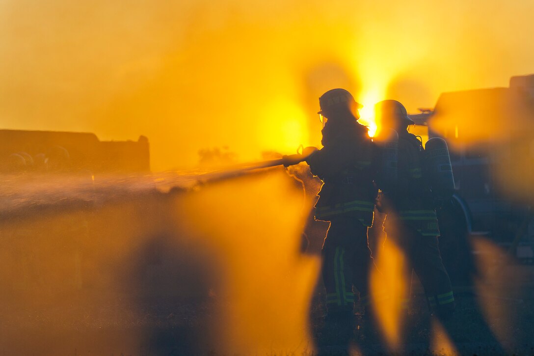 Air Force firefighters conduct fire pit training.