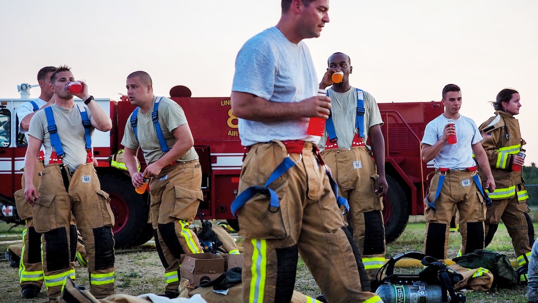 Firefighters hydrate after participating in fire pit training