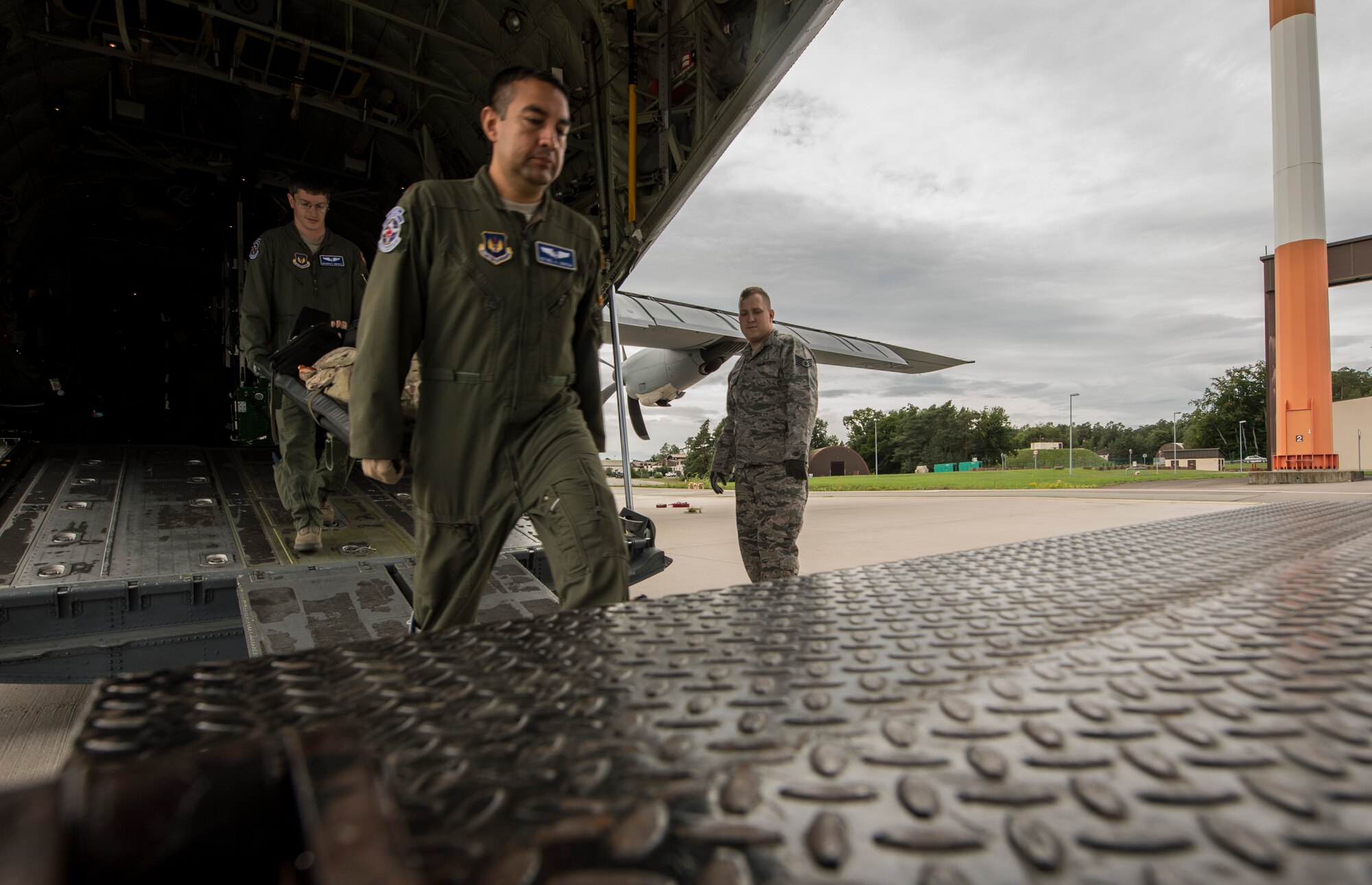 U.S. Air Force Maj. Reynel A. Garcia, 86th Aeromedical Evacuation Squadron chief of standards and evaluations, middle, and U.S. Air Force Capt. Breandan E. Arbuckle, 86th AES flight nurse, carry a medical dummy on a stretcher into a transportation vehicle on Ramstein Air Base, Germany, Aug. 17, 2017. Garcia, Arbuckle, and other 86th AES Airmen flew on a C-130J Super Hercules to Morón Air Base, Spain, Lajes Filed, Portugal, and back to Ramstein Air Base, Germany, to conduct an aeromedical training mission. (U.S. Air Force photo by Senior Airman Tryphena Mayhugh)