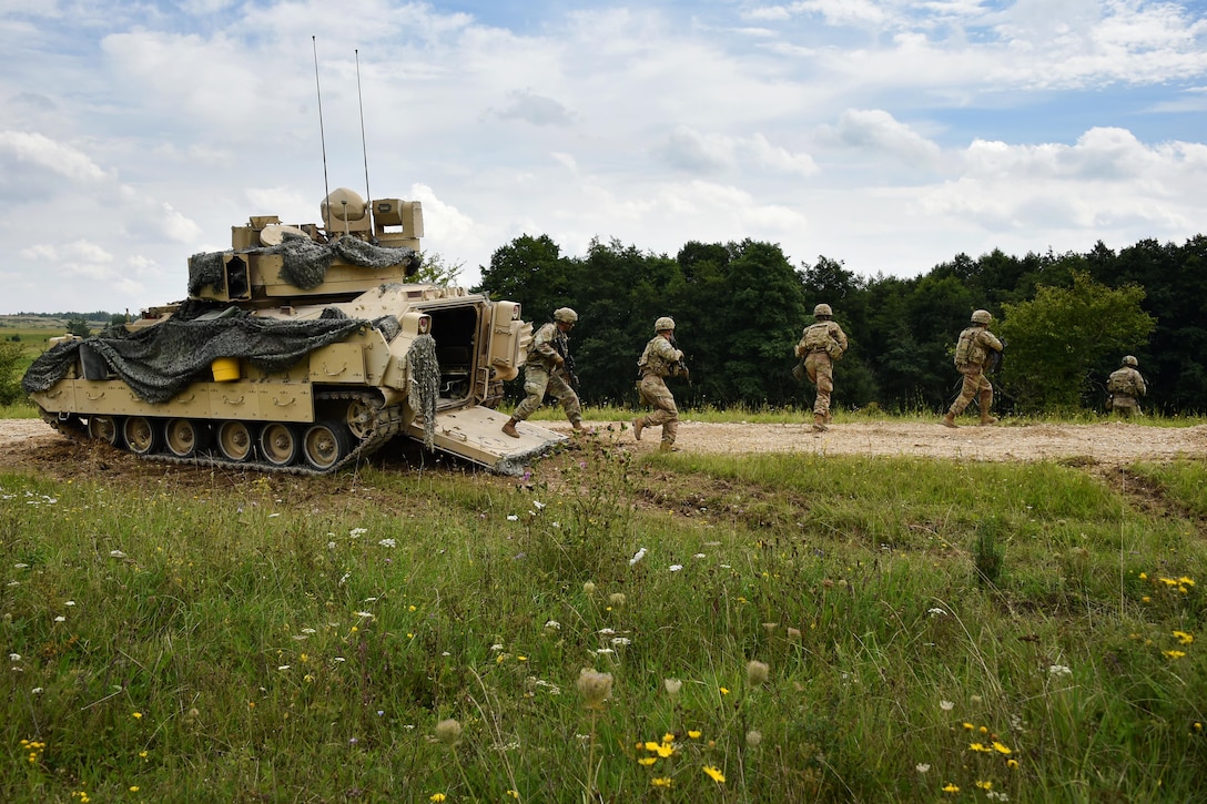 Soldiers dismount a Bradley fighting vehicle.