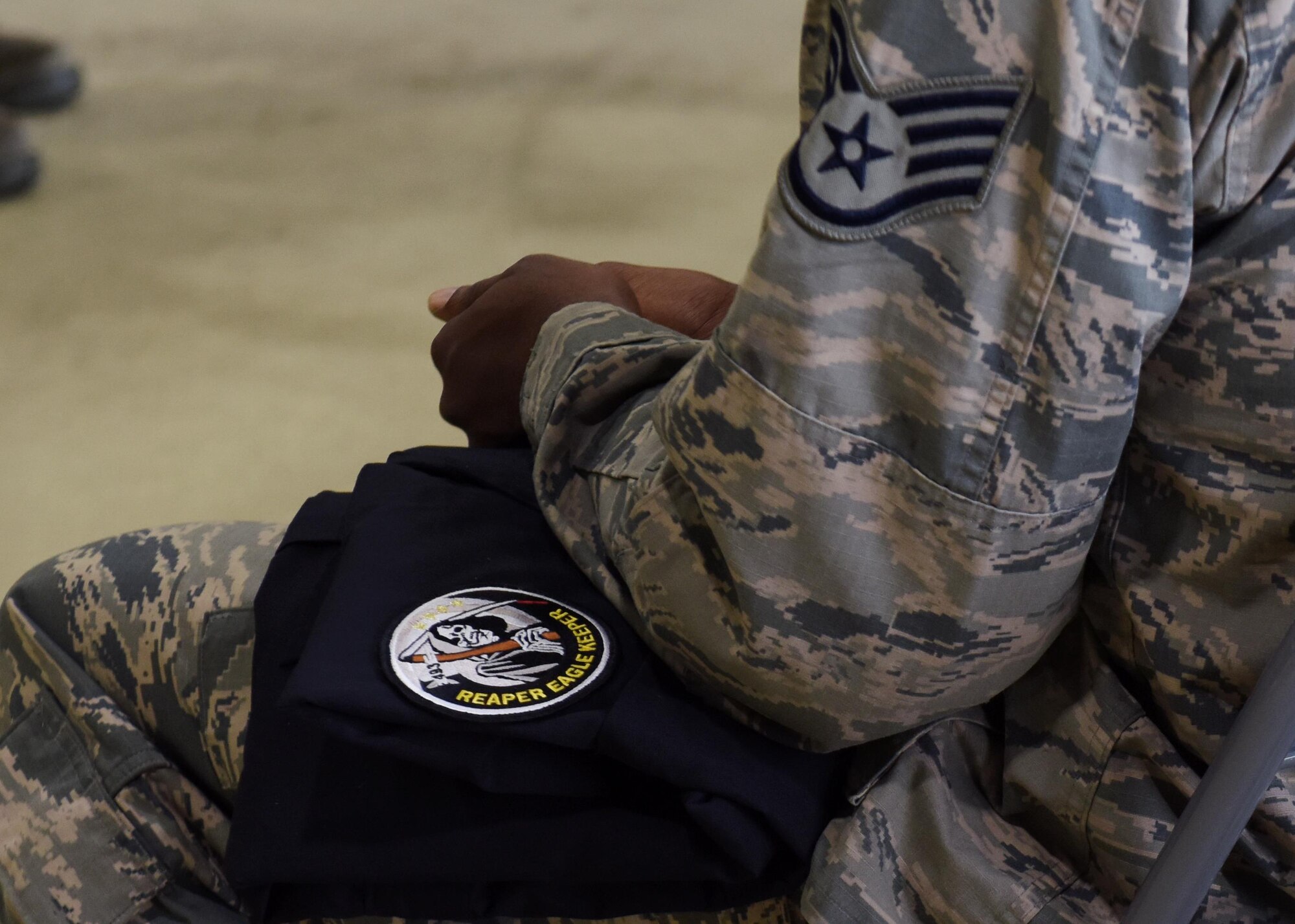 A 748th Aircraft Maintenance Squadron Airman sits with his newly-issued coveralls in his lap at Royal Air Force Lakenheath, England, Aug. 18. As signified by the “Reaper Eagle Keeper” patch, the new crew chiefs will take care of the 493rd Fighter Squadron’s F-15C/D Eagles. (U.S. Air Force photo/Senior Airman Abby L. Finkel)