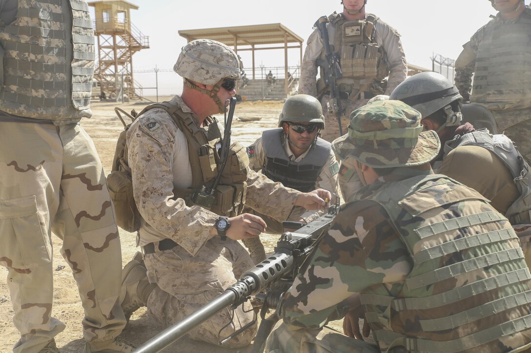 A U.S. Marine advisor with Task Force Southwest demonstrates proper firing techniques on a M2 Browning .50 Machine Gun to Afghan National Army soldiers with the Helmand Regional Military Training Center during a live-fire range at Camp Shorabak, Afghanistan, Aug. 17, 2017. Several advisors with the Task Force are bolstering the infantry knowledge and skills of more than 60 RMTC instructors in preparation for an upcoming operational readiness cycle, an eight-week course designed to enhance the warfighting capabilities and lethality of an infantry kandak, or battalion-sized element of Afghan soldiers. (U.S. Marine Corps photo by Sgt. Lucas Hopkins)