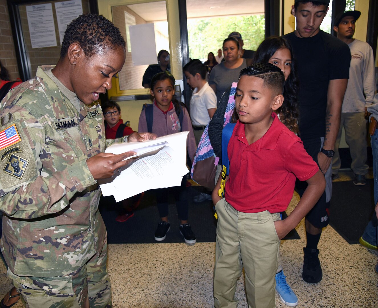 Sgt. 1st Class Ja’Net Chatman from the 470th Military Intelligence Brigade at Joint Base San Antonio-Fort Sam Houston helps a student find his assigned classroom and teacher at the first day of school for Bowden Elementary School.