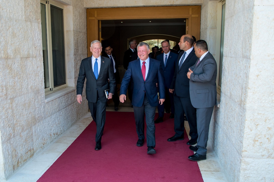 Defense Secretary Jim Mattis walks with the king of Jordan on a red carpet.
