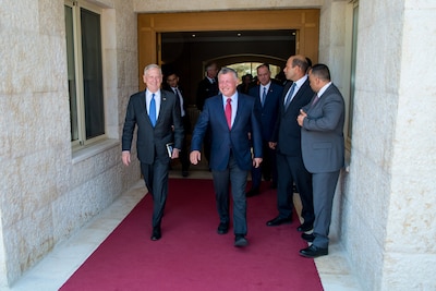 Defense Secretary Jim Mattis walks with King Abdullah II of Jordan on a red carpet.