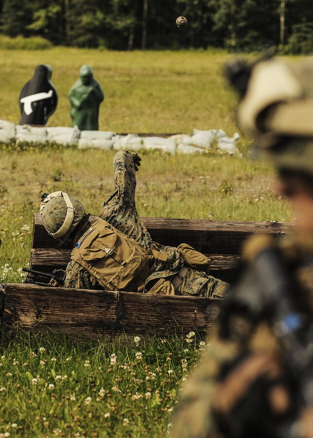 U.S. Marine Corps Lance Corporal Colt Salsburg, a M27 Infantry Automatic Rifleman with 1st Battalion, 25th Marine Regiment, 4th Marine Division, Marine Forces Reserve and a member of 1st Squad hurls a  grenande from the prone position during the Combat Marksmanship Endurance Test Grenade Assault Range in the Small Arms Complex on Joint Base Elmendorf-Richardson, Alaska, Aug. 8, 2017. The Marines and Sailors tested their abilities to conduct the full spectrum of infantry operations during the competition for the title of 4th Marine Division Super Squad. (U.S. Marine Corps photo by Sgt. Justin A. Bopp/Released)