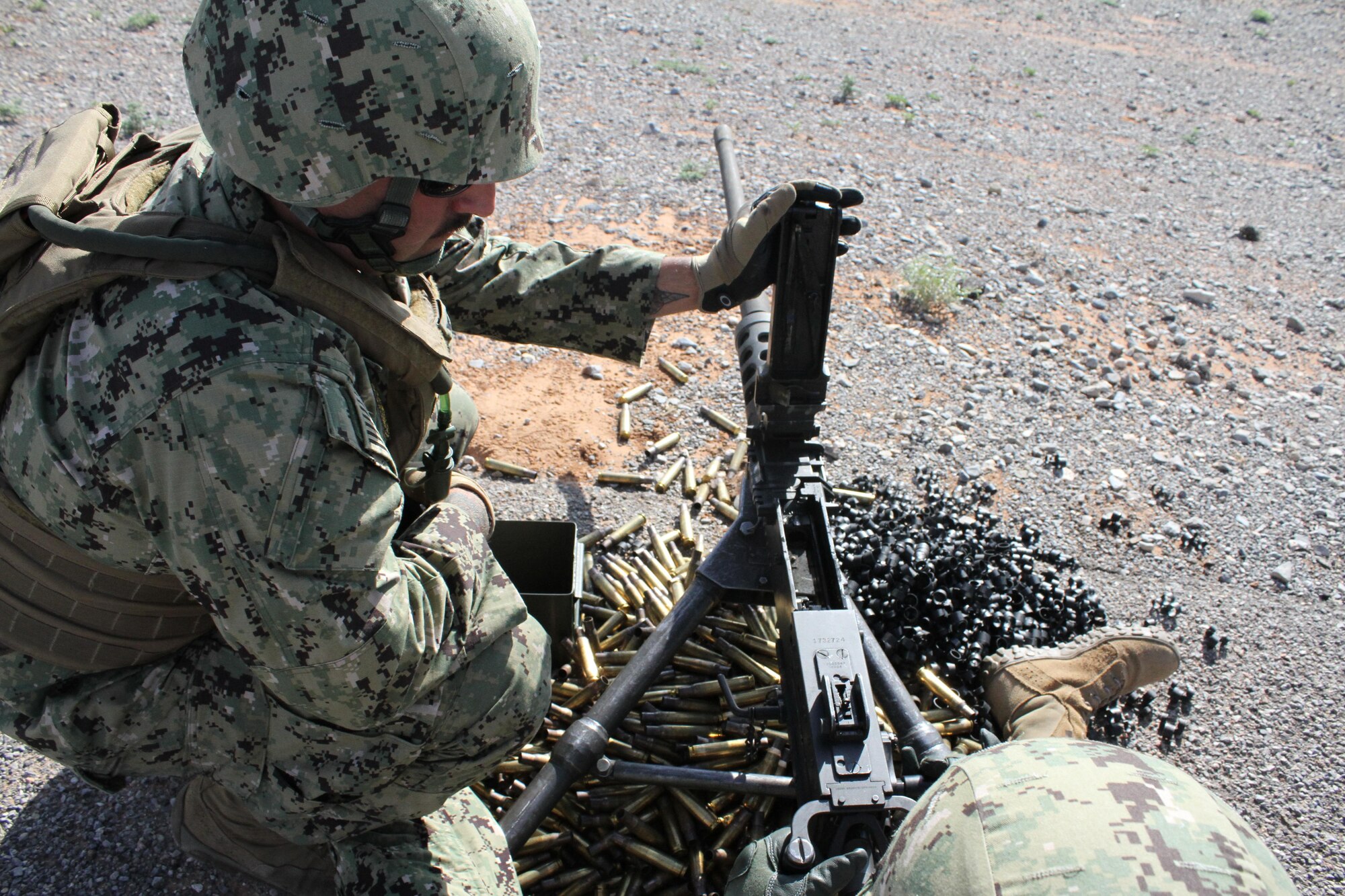 Assistant gunner U.S. Petty Officer 2nd Class Christopher Norberto checks that the chamber is clear on an M2 .50 caliber machine gun during heavy weapons firing on Fort Bliss' Range 39.