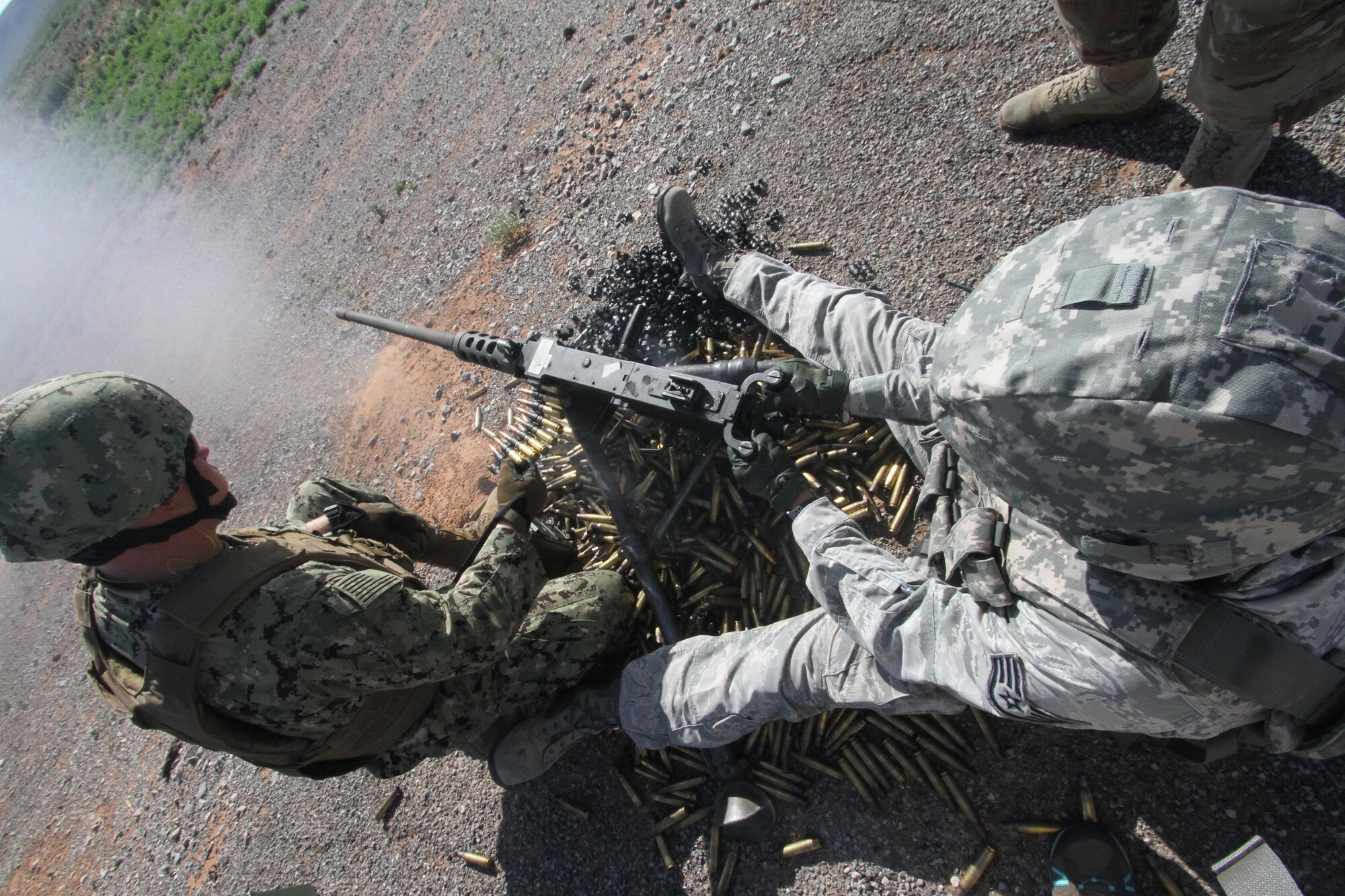 Gunner Staff Sgt. Joshua Hopkins fires the M2 .50 caliber machine gun while assistant gunner U.S. Petty Officer 3rd Class Derek Dick monitors ammunition during heavy weapons firing on Fort Bliss' Range 39.