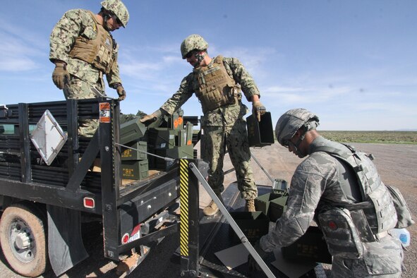 From left, U.S. Navy Petty Officers 2nd Class Zachary Shoemaker and Christopher Norberto, and U.S. Air Force Senior Airman Timothy Montano load up empty ammunition cans after heavy weapons firing at Fort Bliss, Texas, July 26, 2017. The weapons firing was part of the first joint Navy-Air Force basic security course at the Air Force Security Forces Center's Desert Defender Ground Combat Readiness Training Center. (U.S. Air Force photo by Debbie Aragon)