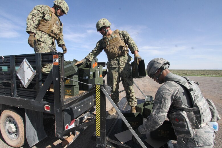 From left, U.S. Navy Petty Officers 2nd Class Zachary Shoemaker and Christopher Norberto, and U.S. Air Force Senior Airman Timothy Montano load up empty ammunition cans after heavy weapons firing at Fort Bliss, Texas, July 26, 2017.