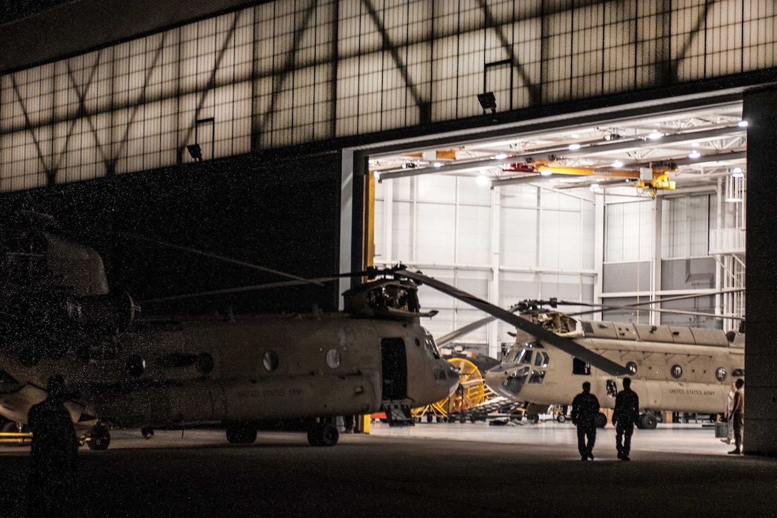Guardsmen prepare their gear in a hanger bay before participating in hoist recovery training.