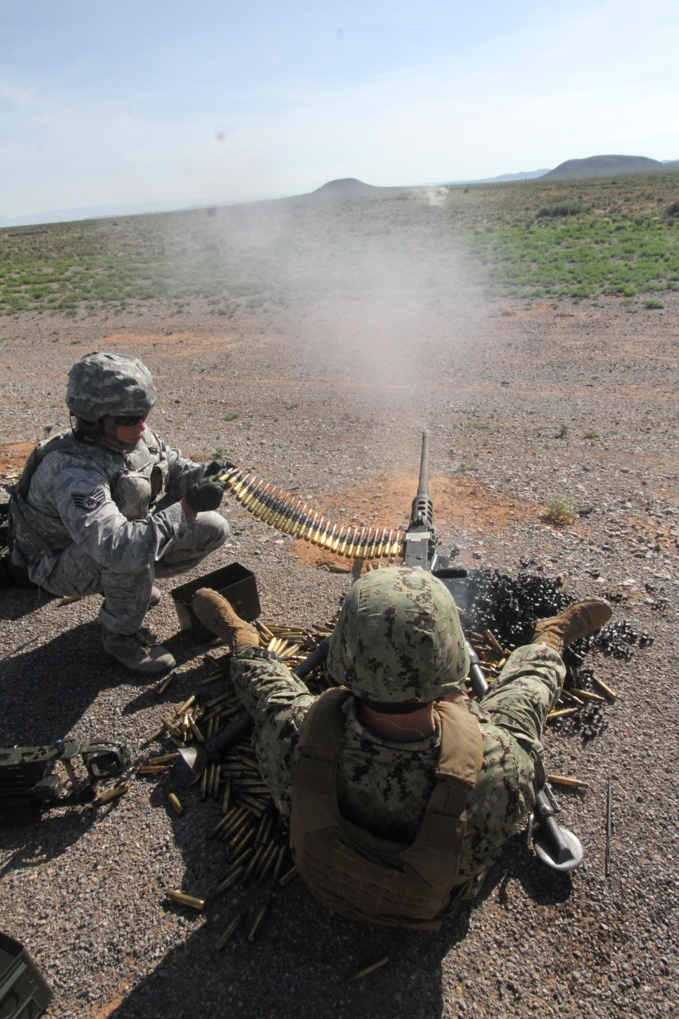 Gunner U.S. Petty Officer 3rd Class Derek Dick fires an M2 .50 caliber machine gun while assistant gunner Staff Sgt. Joshua Hopkins feeds the ammunition during heavy weapons firing on Fort Bliss' Range 39 July 26, 2017.