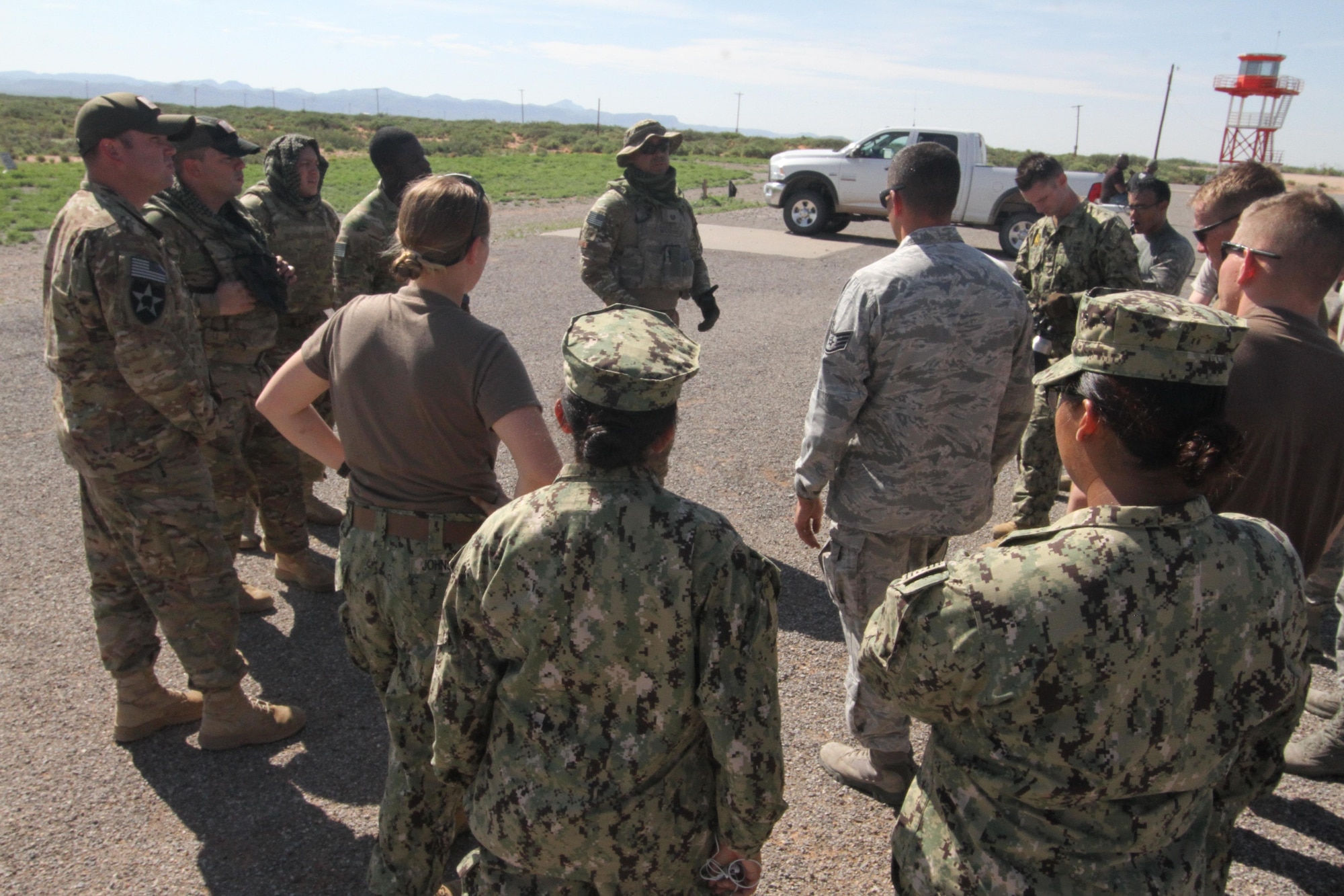 Combat Arms NCO in charge Tech. Sgt. Jose Marrero talks to U.S. Air Force and Navy security forces members following heavy weapons firing at Fort Bliss's Range 39, July 26, 2017.