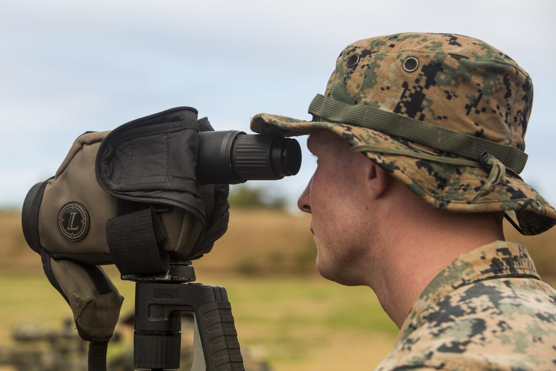 Lance Cpl. William Pearn, a scout sniper candidate with Weapons Company, 2nd Battalion, 3rd Marine Regiment, sights down range as a spotter during a pre-scout sniper course at Pu’uloa Range Training Facility aboard Marine Corps Base Hawaii, August 14, 2017. Spotters help the sniper account for wind, elevation, atmospherics and observe the placement of the last shot the shooter fired. The known distance qualification course is designed to enhance the Marines’ capabilities to engage targets at known distances and alternate positions. (U.S. Marine Corps photo by Lance Cpl. Isabelo Tabanguil)