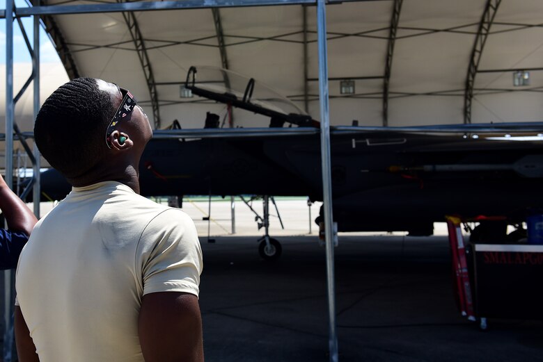 A member of Team Seymour views a solar eclipse through special eye glasses, Aug. 21, 2017, at Seymour Johnson Air Force Base, North Carolina. Special glasses to see the eclipse are required to help prevent eye-damage. (U.S. Air Force photo by Airman 1st Class Kenneth Boyton)
