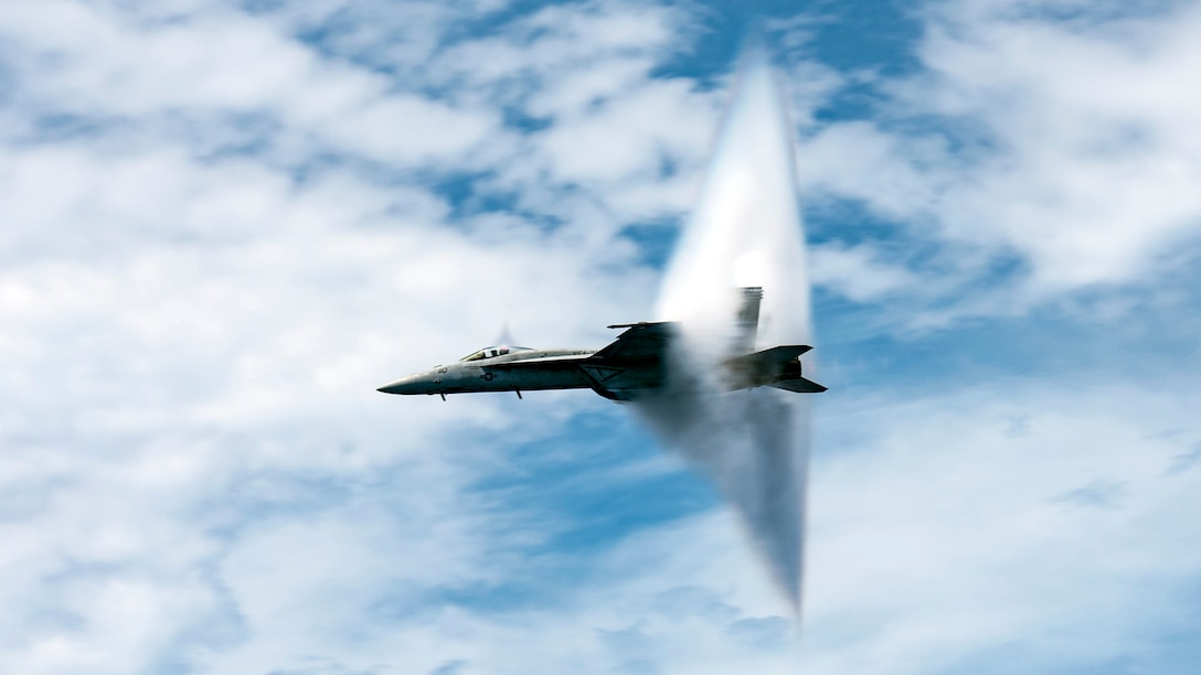 An aircraft bursts through a triangular cloud as the plane breaks the sound barrier.