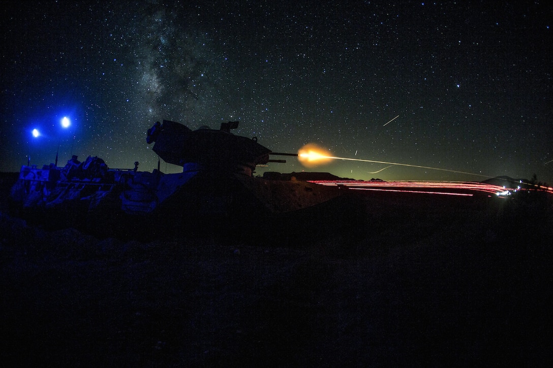 A machine gun blast is visible against a dark sky.