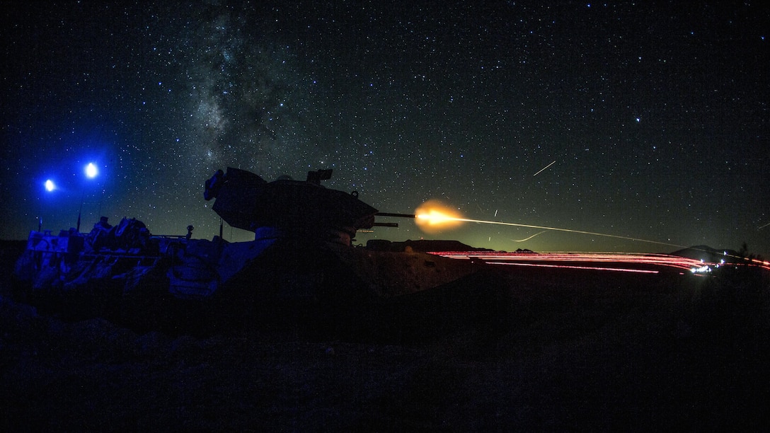 A machine gun blast is visible against a dark sky.