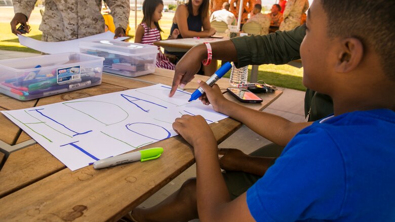 Zarion Gilmore, the son of Chief Warrant Officer 3 Marcus Gilmore, personnel officer, 7th Marine Regiment, makes a sign for his father prior to the unit’s homecoming at Victory Park aboard the Marine Corps Air Ground Combat Center, August 17, 2017. 7th Marines completed their nine month deployment as the command element of Special Purpose Marine Air-Ground Task Force – Crisis Response – Central Command 17.1. (U.S. Marine Corps photo by Lance Cpl. Isaac Cantrell)