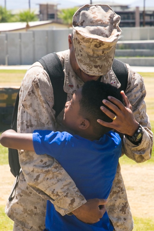 Chief Warrant Officer 3 Marcus Gilmore, personnel officer, 7th Marine Regiment, hugs his son, Zarion Gilmore, at Victory Park aboard the Marine Corps Air Ground Combat Center, August 18, 2017. 7th Marines completed a nine month deployment as the command element of Special Purpose Marine Air-Ground Task Force – Crisis Response – Central Command 17.1. (U.S. 
Marine Corps photo by Lance Cpl. Isaac Cantrell)
