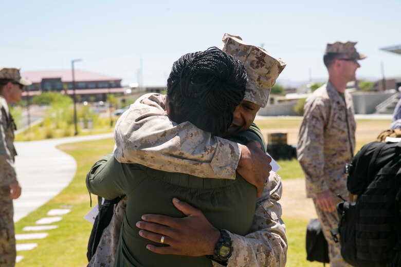 Chief Warrant Officer 3 Marcus Gilmore, personnel officer, 7th Marine Regiment, hugs his wife at Victory Park aboard the Marine Corps Air Ground Combat Center, August 18, 2017. 7th Marines completed a nine month deployment as the command element of Special Purpose Marine Air-Ground Task Force – Crisis Response – Central Command 17.1. (U.S. Marine Corps photo by Lance Cpl. Isaac Cantrell)