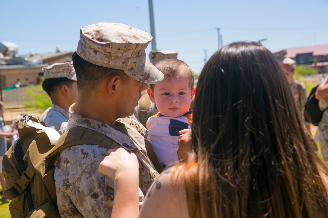 Sgt. Krystian Madrid, intelligence specialist, 7th Marine Regiment, holds his son following his unit’s homecoming at Victory Park aboard the Marine Corps Air Ground Combat Center, August 17, 2017. 7th Regiment Marines completed a nine month deployment as the command element of Special Purpose Marine Air-Ground Task Force – Crisis Response – Central Command 17.1. (U.S. Marine Corps photo by Lance Cpl. Isaac Cantrell)