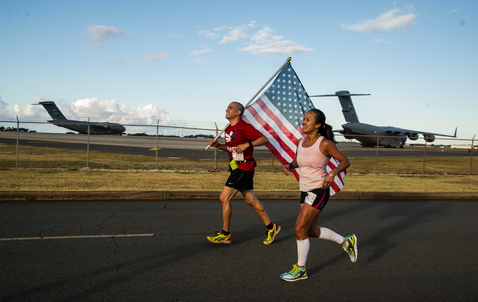 A runner carries the U.S. flag during the 11th Annual Hickam Half Marathon, Joint Base Pearl Harbor-Hickam, Hawaii, Aug. 19, 2017.
