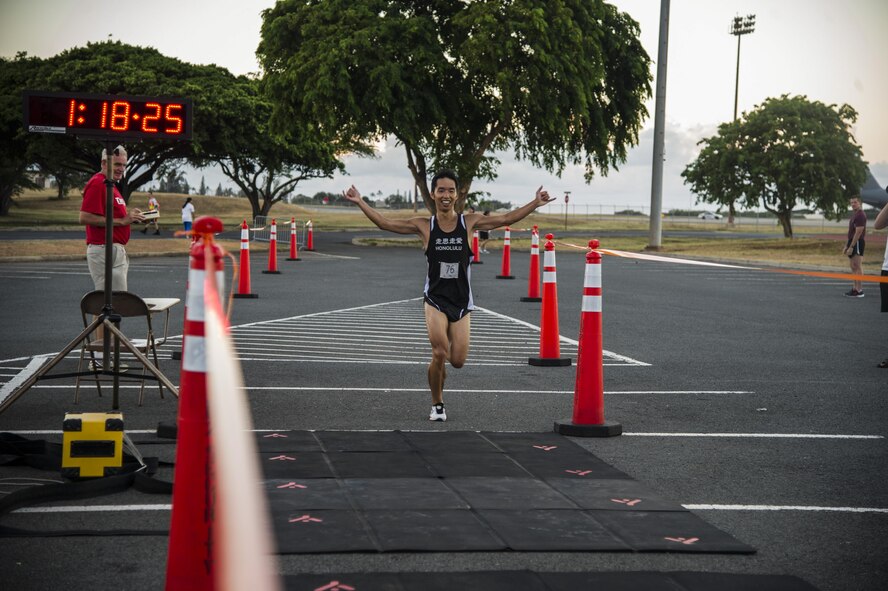 Kazuki Ishii crosses the finish line, taking first place in the male open category during the 11th Annual Hickam Half Marathon, Joint Base Pearl Harbor-Hickam, Hawaii, Aug. 19, 2017.