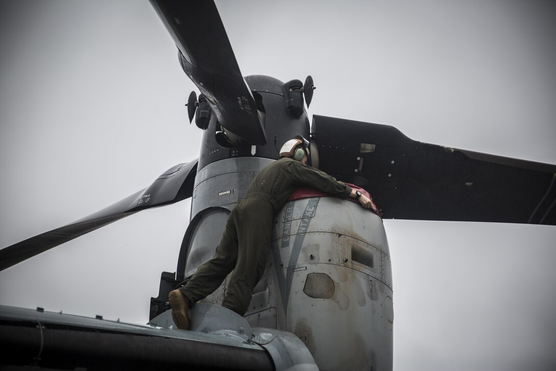 A U.S. Marine puts a cover on a MV-22 Osprey at Misawa Air Base, Japan, for exercise Northern Viper 2017, August 9, 2017.