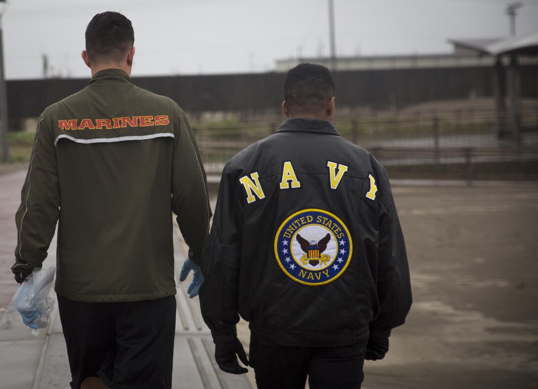 A U.S. Marine and Sailor search for trash at Miss Veedol Beach, Misawa, Japan, August 19, 2017, during Exercise Northern Viper 2017. Marines, Sailors, Airmen banded together with Misawa City employees to participate in the beach cleanup. NV17 tests the interoperability and bilateral capability of the Japan Ground Self-Defense Force and U.S. Marine Corps forces to enhance regional cooperation between participating nations to collectively deter security threats. (U.S. Marine Corps photo by Lance Cpl. Andy Martinez)