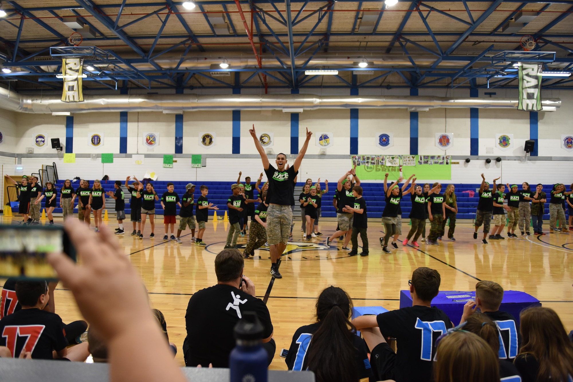 Students from the green team show the judges their team cheer during ‘The RACE’ at Royal Air Force Lakenheath, England, Aug. 14, 2017. Student’s cheers were graded on several factors including creativity, group cohesion and overall style. (U.S. Air Force photo by Airman 1st Class John A. Crawford)