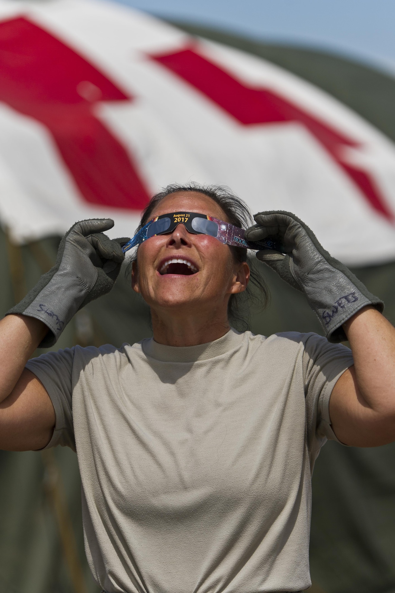 U.S. Air Force Lt. Col. Amy Swets, assigned to the 445th Aeromedical Staging Squadron, Wright-Patterson AFB, Ohio, observes through her eclipse glasses as the moon passes in front of the sun during a total solar eclipse at Young Air Assault Strip, Fort McCoy, Wis., Aug. 21, 2017, while participating in exercise Patriot Warrior. More than 600 Reserve Citizen Airmen and over 10,000 soldiers, sailors, Marines and international partners converged on the state of Wisconsin to support a range of interlinked exercises including Patriot Warrior, Global Medic, CSTX, Diamond Saber, and Mortuary Affairs Exercise (MAX).  Patriot Warrior is Air Force Reserve Command's premier exercise, providing an opportunity for Reserve Citizen Airmen to train with joint and international partners in airlift, aeromedical evacuation and mobility support.  This exercise is intended to test the ability of the Air Force Reserve to provide combat-ready forces to operate in dynamic, contested environments and to sharpen Citizen Airmen's skills in supporting combatant commander requirements. ( U.S. Air Force Photo by Tech. Sgt. Efren Lopez )