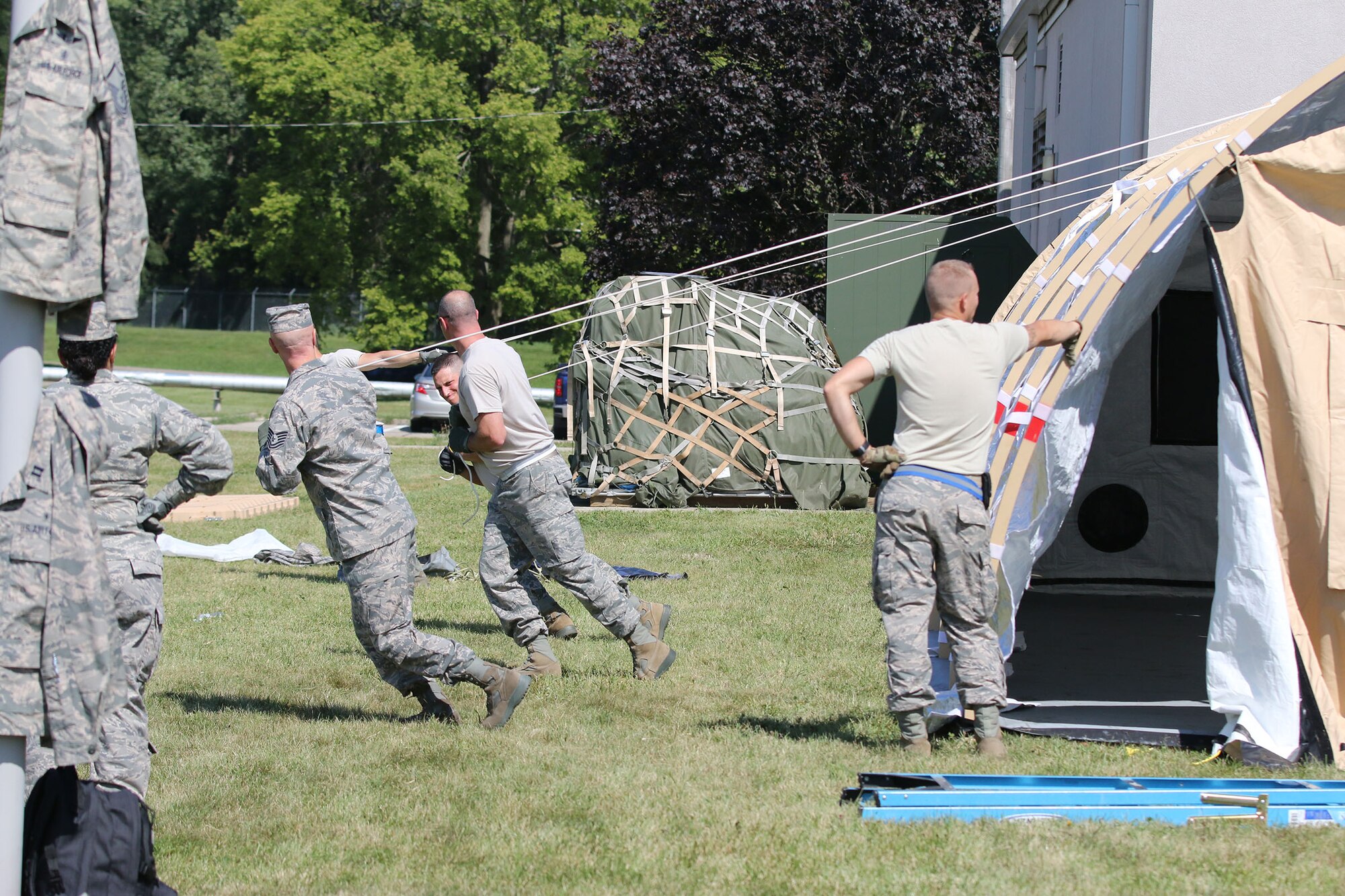 Members of the 445th Aeromedical Staging Squadron pull the ropes to prone an Alaska shelter here August 14, 2017.