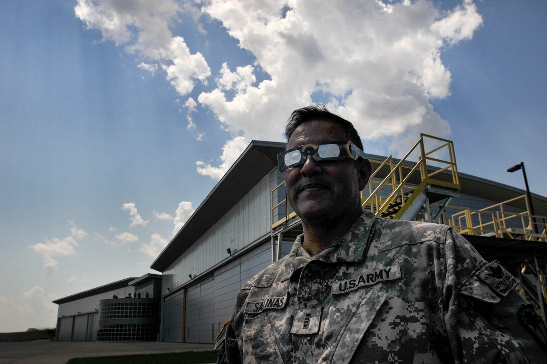 A soldier watches the solar eclipse using glasses.