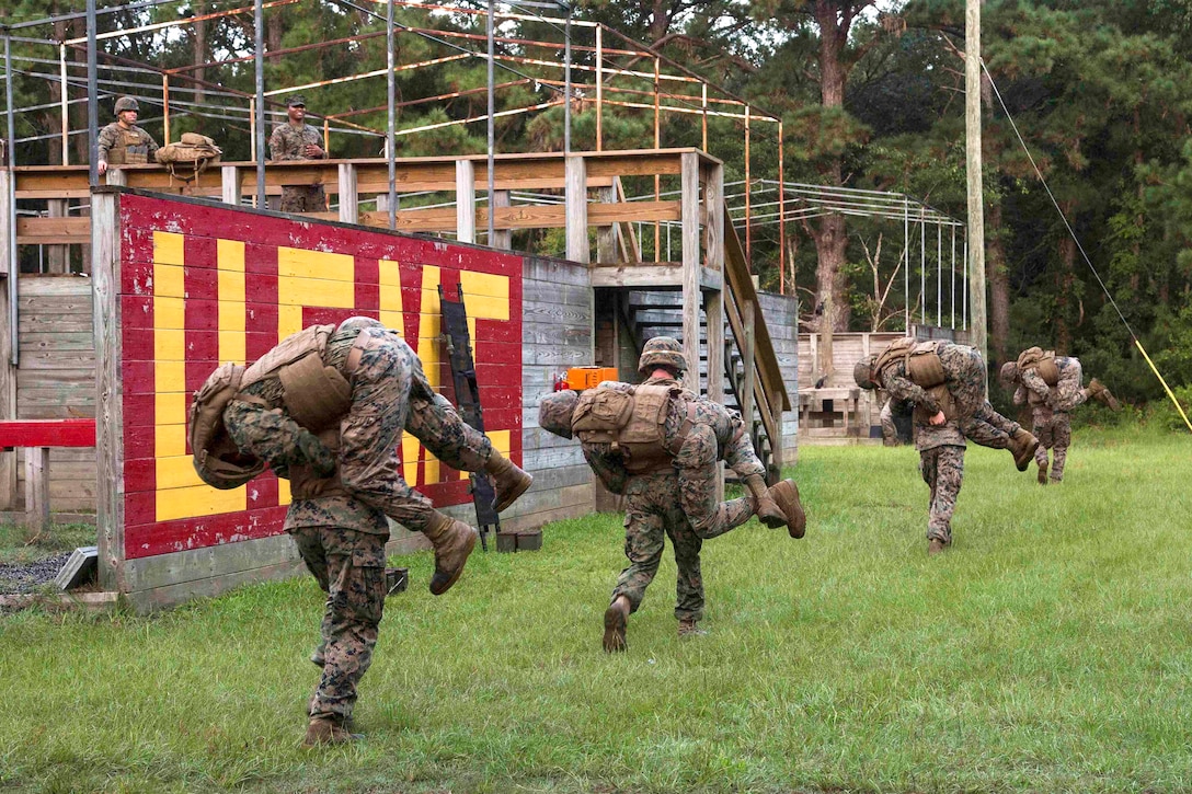 Marines perform a fireman carry during the Leadership Reaction Course