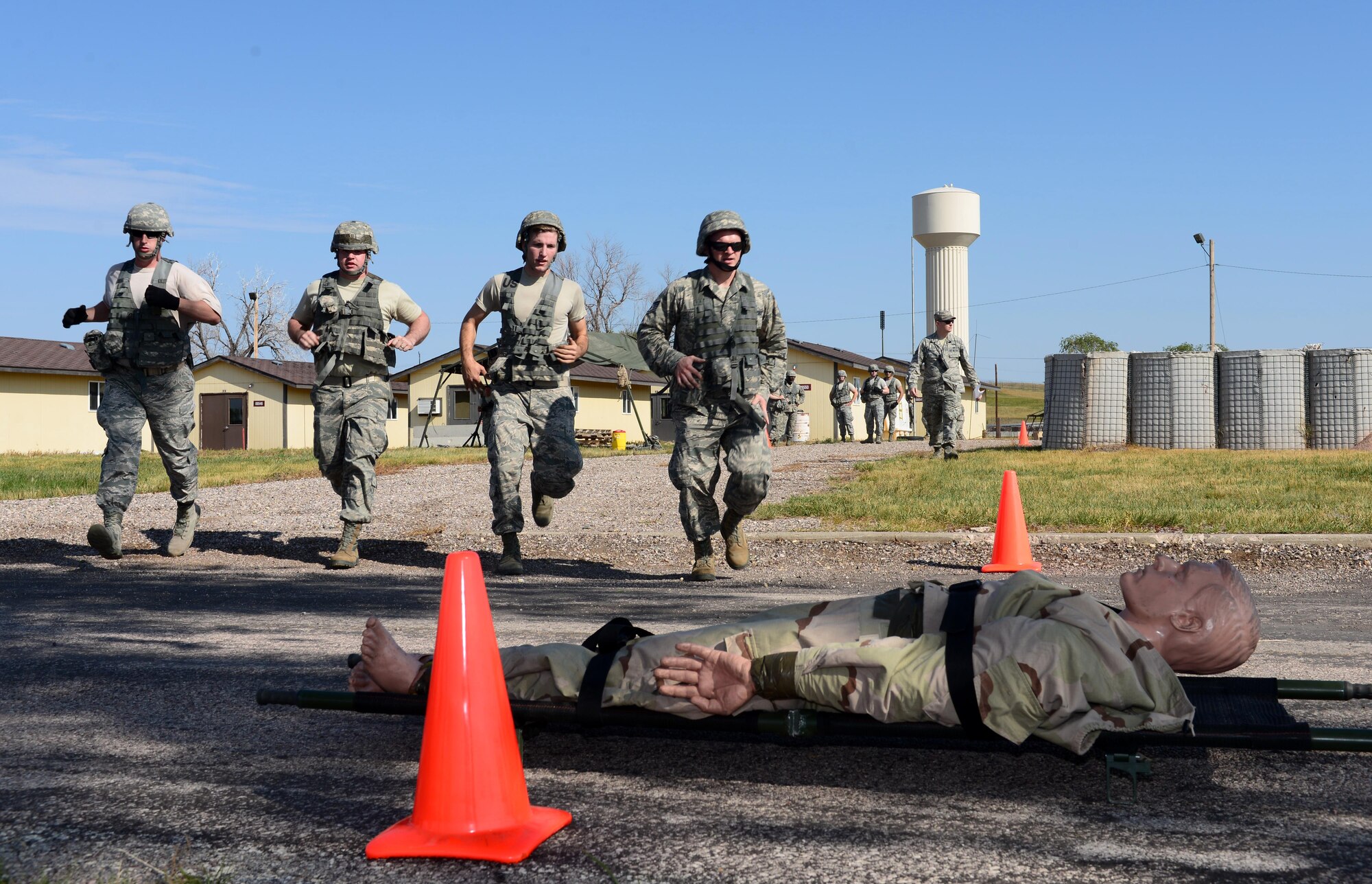 Airmen assigned to the 28th Civil Engineer Squadron rush over to complete a litter carry with a training dummy during the Prime Base Engineer Emergency Force (BEEF) challenge at Ellsworth Air Force Base, S.D., Aug. 17, 2017.