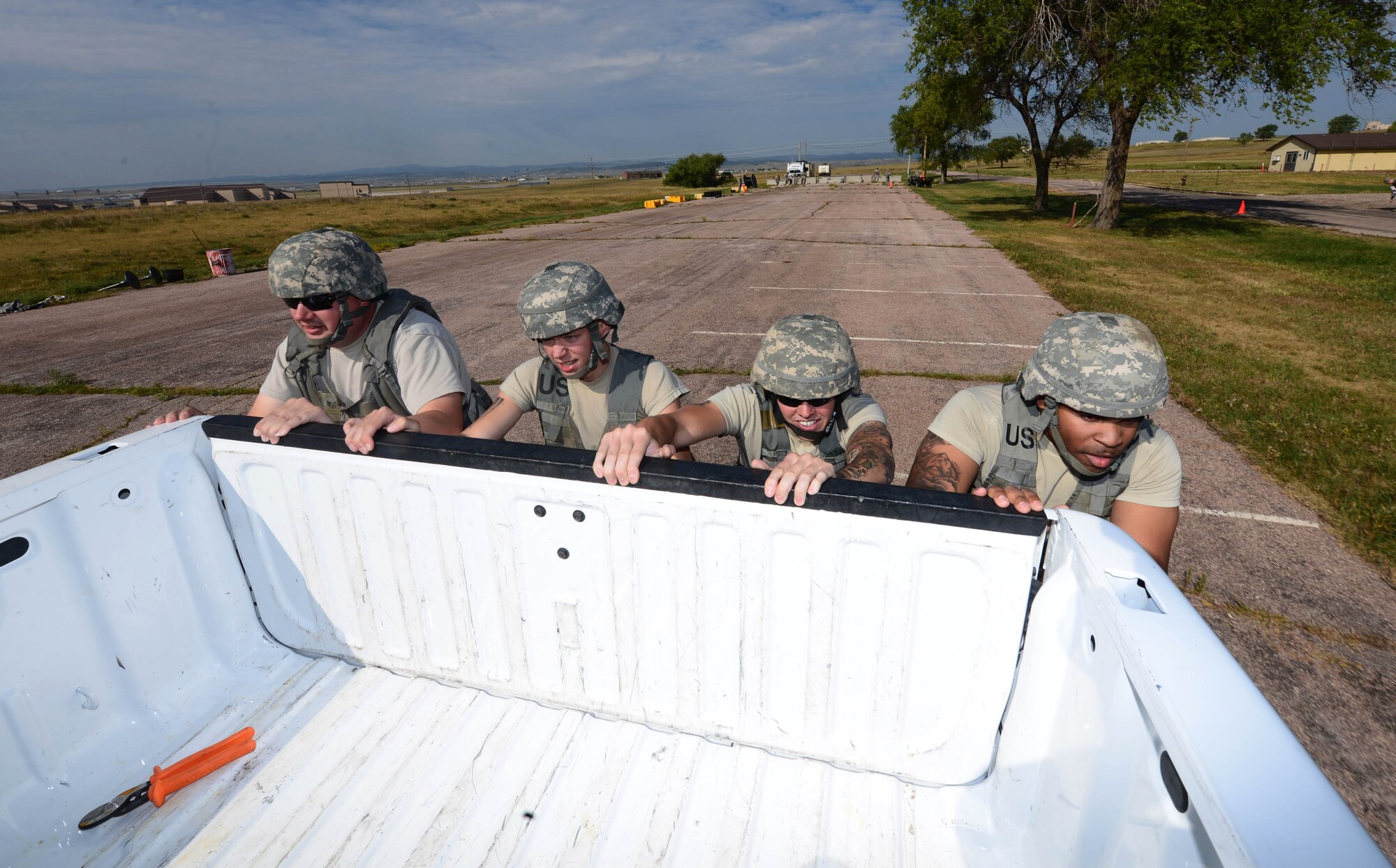 Airmen assigned to the 28th Civil Engineer Squadron push a six-passenger vehicle during the Prime Base Engineer Emergency Force (BEEF) challenge at Ellsworth Air Force Base, S.D., Aug. 17, 2017.