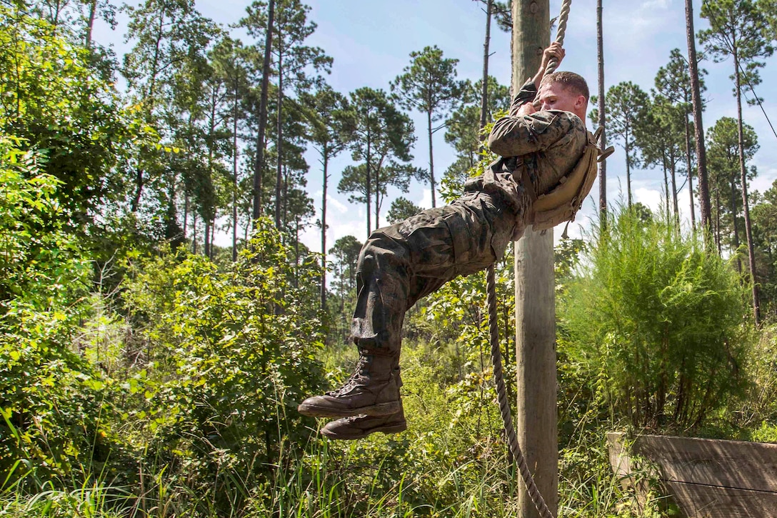 Marine Corps Cpl. Christopher T. Flowers swings on a rope during the Combat Endurance Course.