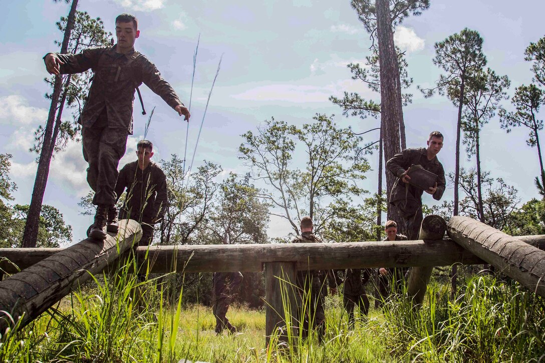 Marines participate in the log balance obstacle.