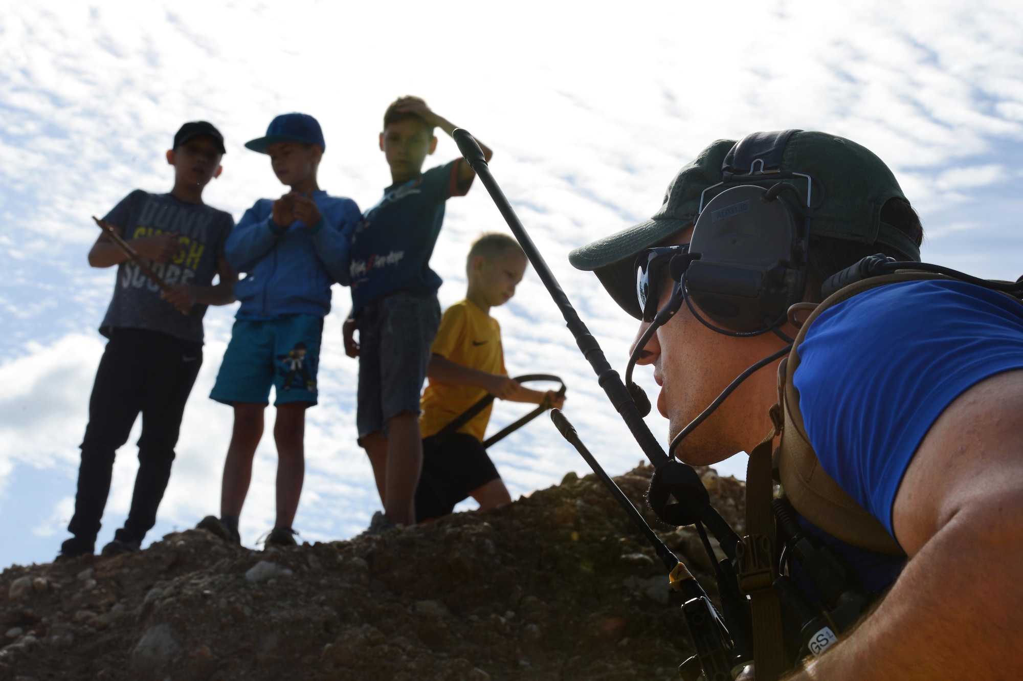 An Air Force combat controller with the 321st Special Tactics Squadron takes cover from simulated gunfire during close air support training as local children play, Aug. 8, 2017, in Rakevere, Estonia. Throughout the scenario, instructors inundated the controllers with information and chaos -- constantly moving through the village and coordinating simulated strikes with A-10s overhead. (U.S. Air Force photo by Staff Sgt. Sandra Welch)