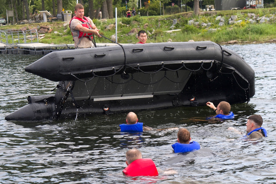 Two guardsmen right a flipped boat,