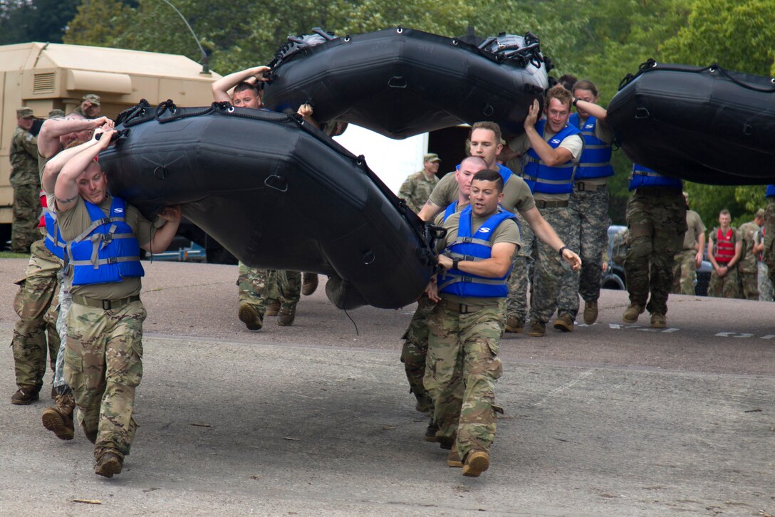 Guardsmen carry inflatable boats.